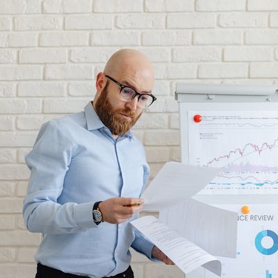 Male financial analyst reviewing business performance metrics and reports